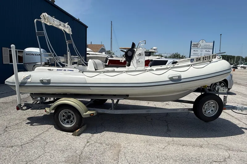 The Image of 2014 Marlago 520CC boat on trailer, parked outdoors near marina. - 1