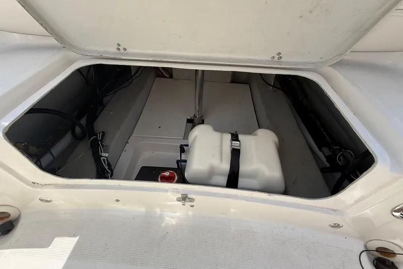 Slide: The Image of Open storage compartment of 2014 Marlago 520CC boat, showing interior equipment and wiring. - 15