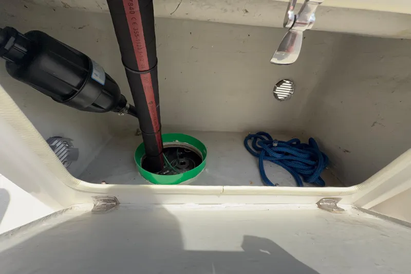 Slide: The Image of Storage compartment of a 2014 Marlago 520CC boat with rope and plumbing components. - 14