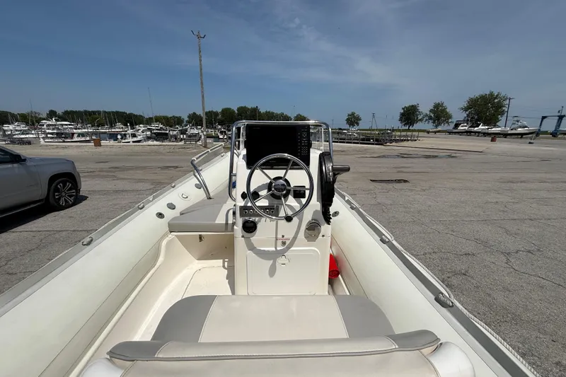 Slide: The Image of 2014 Marlago 520CC boat interior with steering wheel, docked at marina under clear sky. - 6