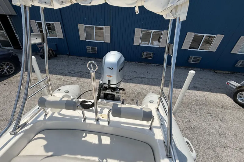 Slide: The Image of 2014 Marlago 520CC boat with Honda 90 outboard motor, docked near blue building. - 5