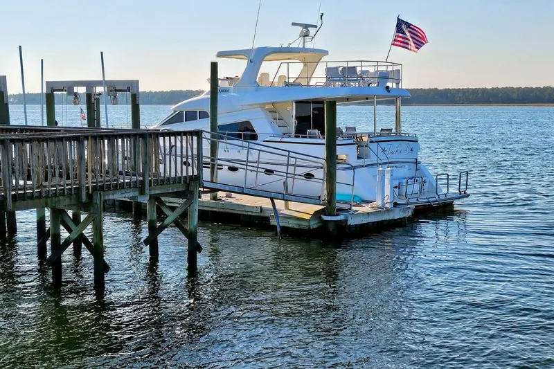 Slide: The Image of Luxury yacht docked at marina, Johnson FLY 2003 model, with American flag. - 2