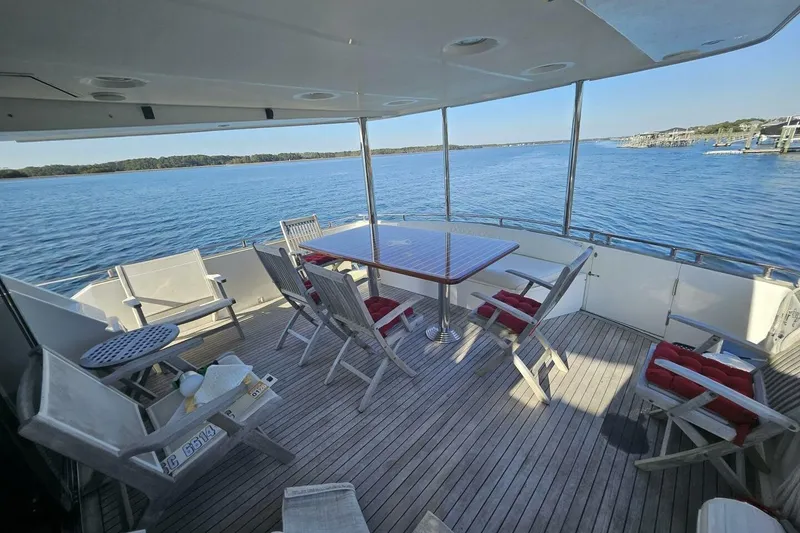 Slide: The Image of Spacious deck of 2003 Johnson FLY yacht with seating, overlooking serene waters. - 4