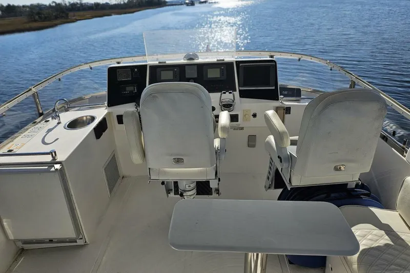 Slide: The Image of Cockpit of 2003 Johnson FLY boat with dual seats and control panels on a sunny day. - 11