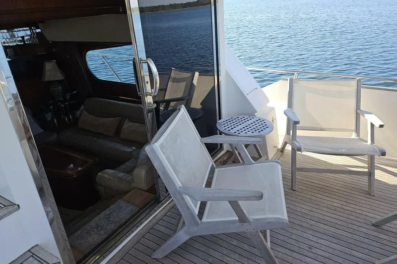 Slide: The Image of 2003 Johnson FLY yacht deck with chairs, table, and ocean view. - 8