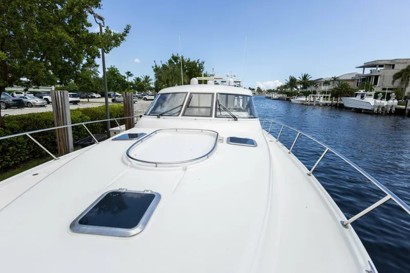 Slide: The Image of 2000 Tiara Yachts 5200 Express on a serene waterway, showcasing sleek design and luxury. - 24