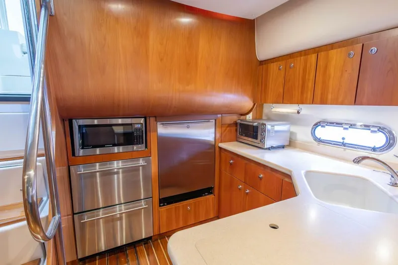 Slide: The Image of Luxurious 2000 Tiara Yachts 5200 Express kitchen with wood cabinetry and modern appliances. - 11