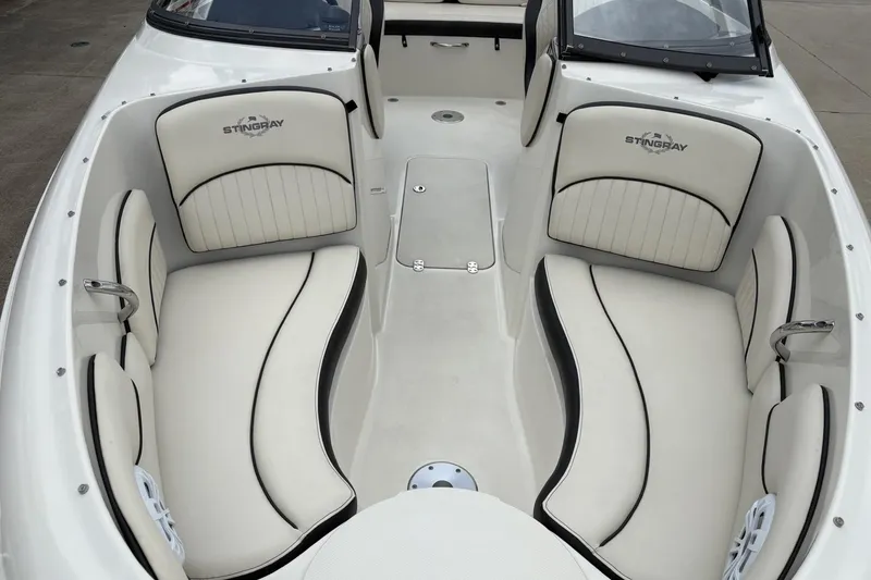 Slide: The Image of 2021 Stingray 204 LR boat interior with white cushioned seating and sleek design. - 8