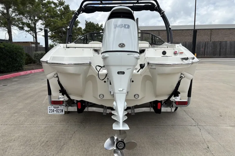 Slide: The Image of Rear view of a 2021 Stingray 204 LR boat with outboard motor in a parking lot. - 4