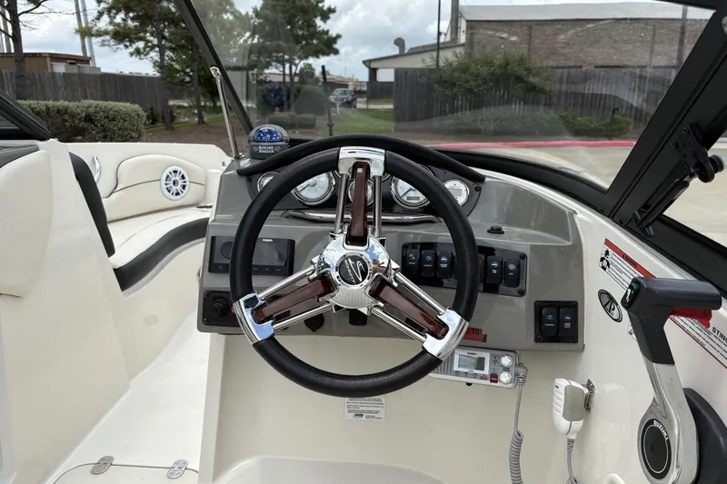 Slide: The Image of 2021 Stingray 204 LR boat dashboard with steering wheel and control panel. - 5