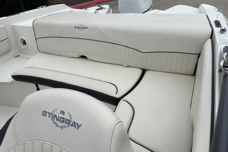Slide: The Image of 2021 Stingray 204 LR boat interior with white cushioned seating and logo embroidery. - 9