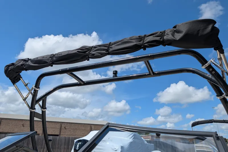 Slide: The Image of 2021 Stingray 204 LR boat with folded black canopy against blue sky. - 11