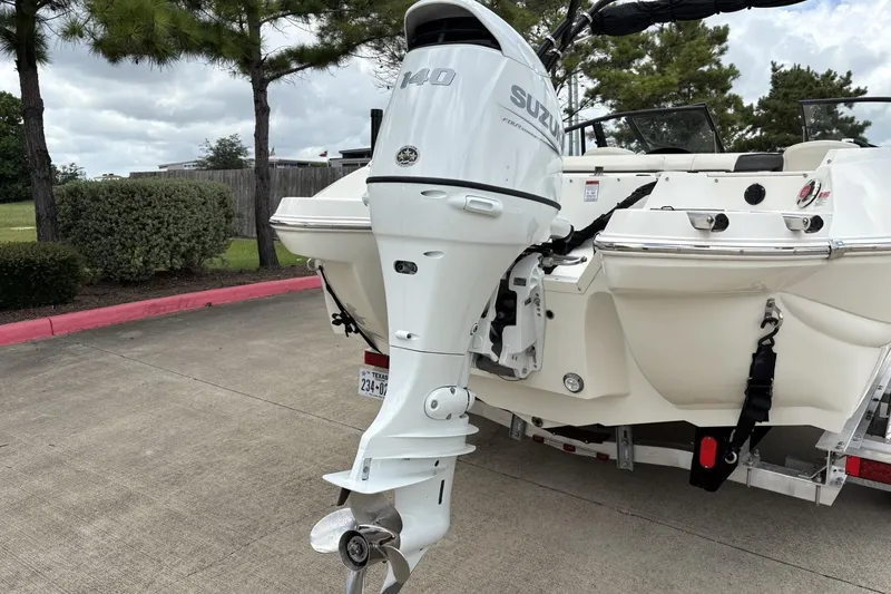 Slide: The Image of 2021 Stingray 204 LR boat with Suzuki outboard motor, parked on concrete. - 3