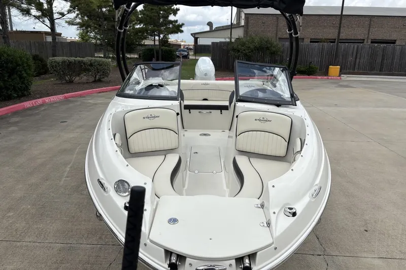 Slide: The Image of 2021 Stingray 204 LR boat with open bow seating, parked on concrete. - 7