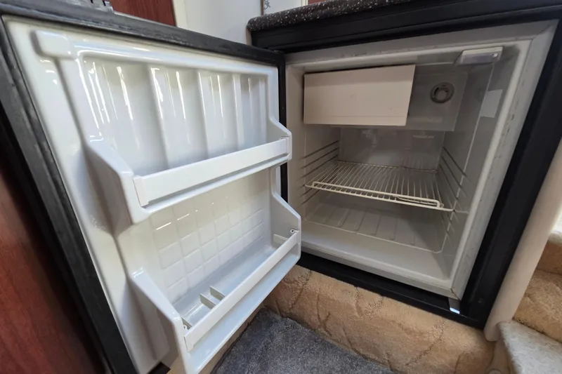 Slide: The Image of Open mini fridge inside a 2004 Formula 370 Super Sport boat. - 28