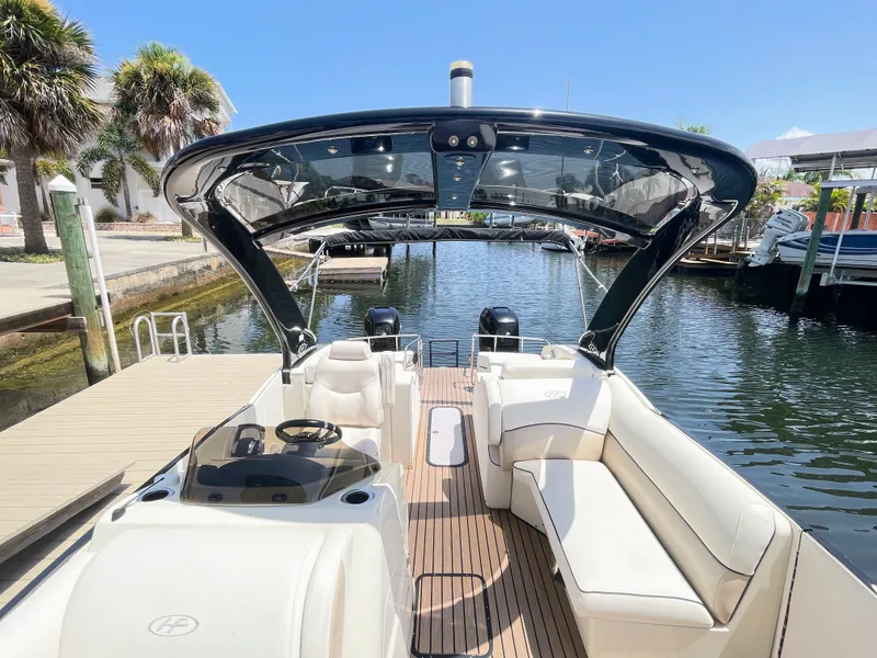 Slide: The Image of A luxurious pontoon boat with a curved canopy and comfortable seating, docked at a serene harbor. - 47