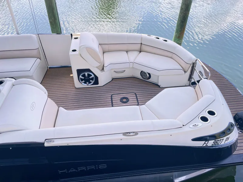 Slide: The Image of The image shows the deck of a 2015 Harris FloteBote Crown DL 250 with sleek white seating. - 6