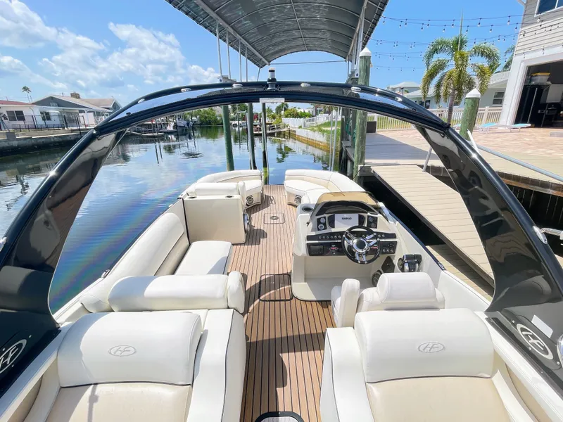 Slide: The Image of The image shows a luxurious pontoon boat with white seating and a sleek helm, docked at a marina. - 27