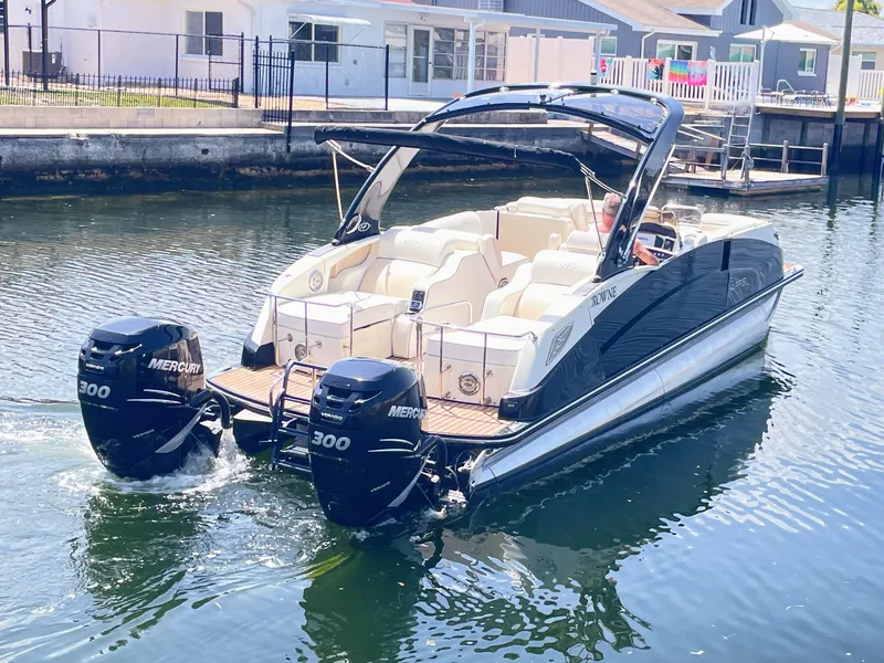 Slide: The Image of A luxurious pontoon boat with twin Mercury engines cruising on a calm waterway. - 3