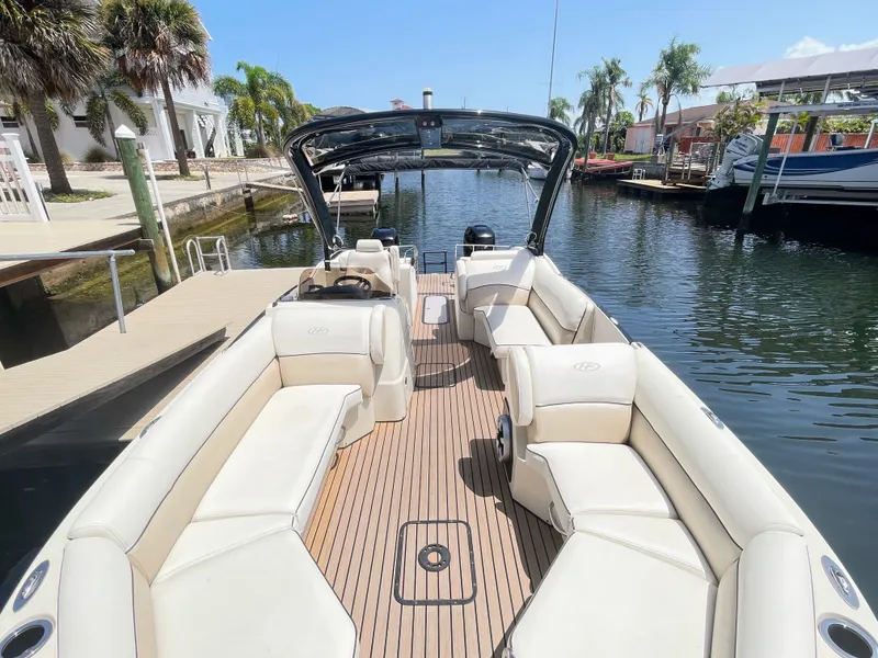 Slide: The Image of 2015 Harris FloteBote Crown DL 250 pontoon boat with sleek white seating and teak flooring, docked. - 45