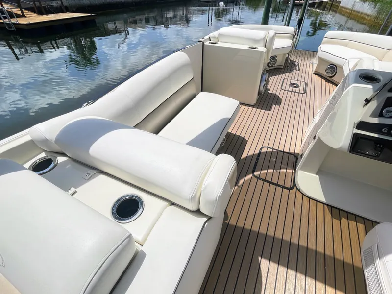 Slide: The Image of The image shows the deck of a 2015 Harris FloteBote Crown DL 250 with white cushioned seating. - 28