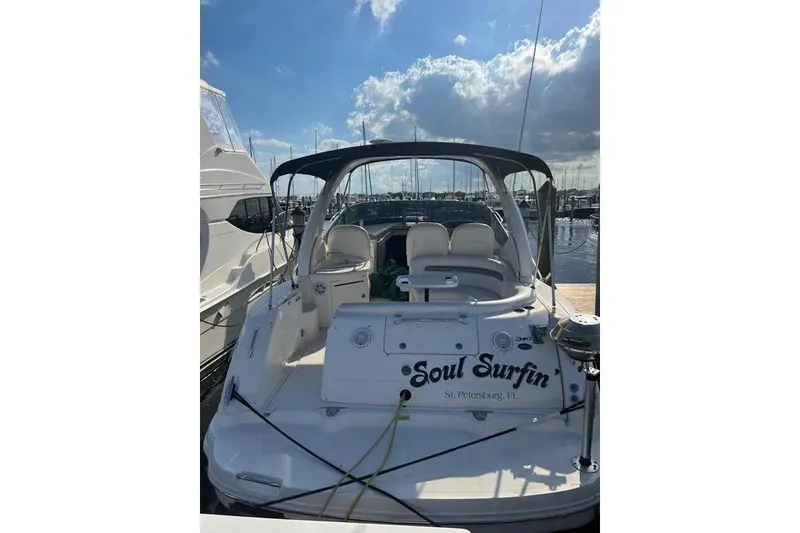 Slide: The Image of 2006 Sea Ray 340 Sundancer boat docked, named "Soul Surfin," under a partly cloudy sky. - 1