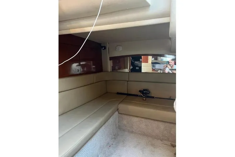 Slide: The Image of Interior cabin of 2006 Sea Ray 340 Sundancer with beige seating and fishing rod. - 5