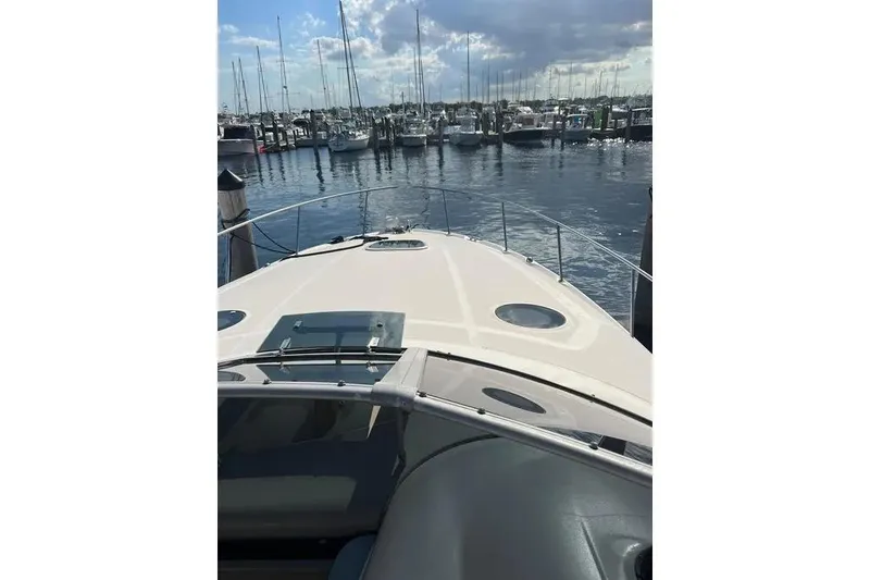 Slide: The Image of 2006 Sea Ray 340 Sundancer yacht docked at a marina under a partly cloudy sky. - 2