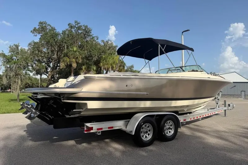 Slide: The Image of 2018 Chris-Craft Corsair 30 boat on trailer, parked outdoors under clear sky. - 3
