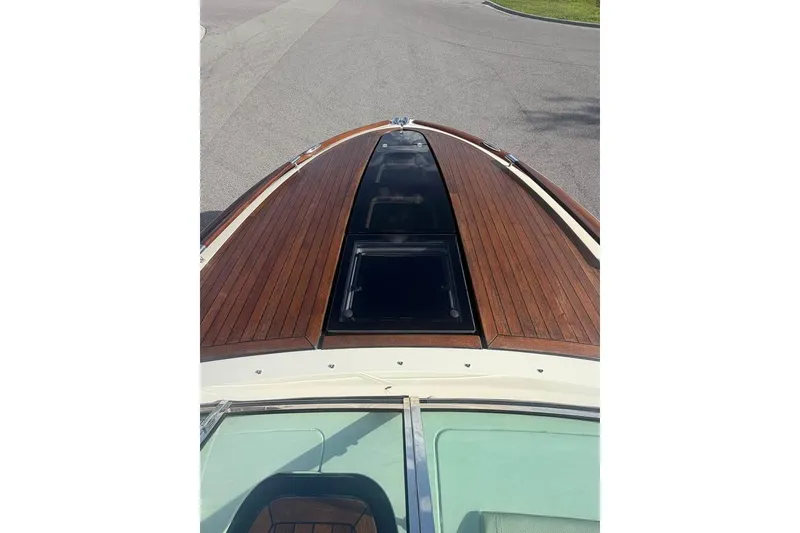 Slide: The Image of 2018 Chris-Craft Corsair 30 boat with elegant wooden deck and sleek design. - 9