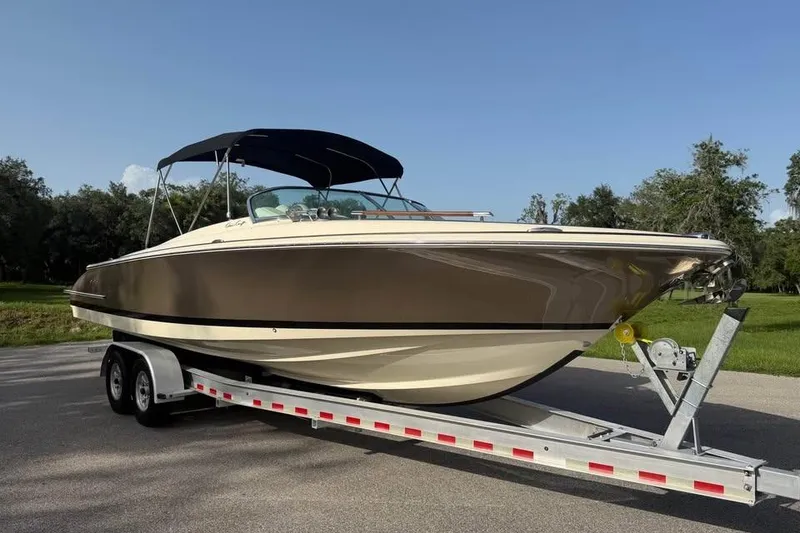 Slide: The Image of 2018 Chris-Craft Corsair 30 boat on trailer, parked outdoors under clear sky. - 4