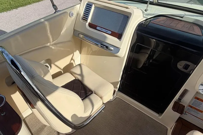 Slide: The Image of Interior of a 2018 Chris-Craft Corsair 30 boat, featuring a beige captain's seat and dashboard. - 11