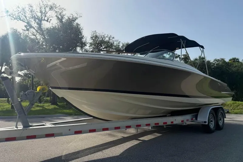 Slide: The Image of 2018 Chris-Craft Corsair 30 boat on trailer, parked outdoors under clear sky. - 1