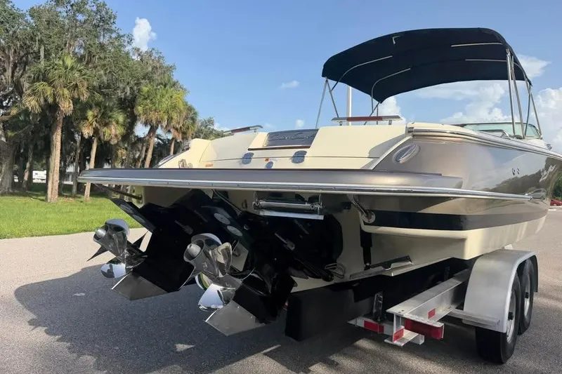 Slide: The Image of 2018 Chris-Craft Corsair 30 boat on trailer, parked near palm trees under a clear sky. - 8