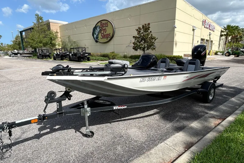 Slide: The Image of 2020 Triton 18 TX boat on trailer outside Bass Pro Shops, sunny day. - 3