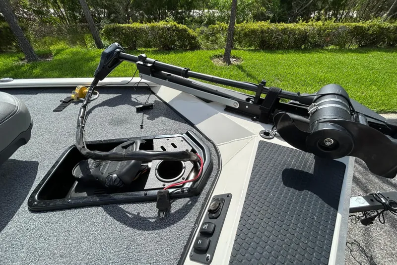 Slide: The Image of 2020 Triton 18 TX boat deck with trolling motor and control panel in a grassy setting. - 16