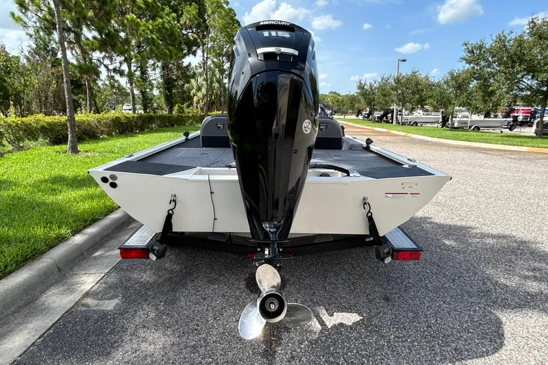 Slide: The Image of 2020 Triton 18 TX boat with Mercury engine on trailer, parked on sunny road. - 6