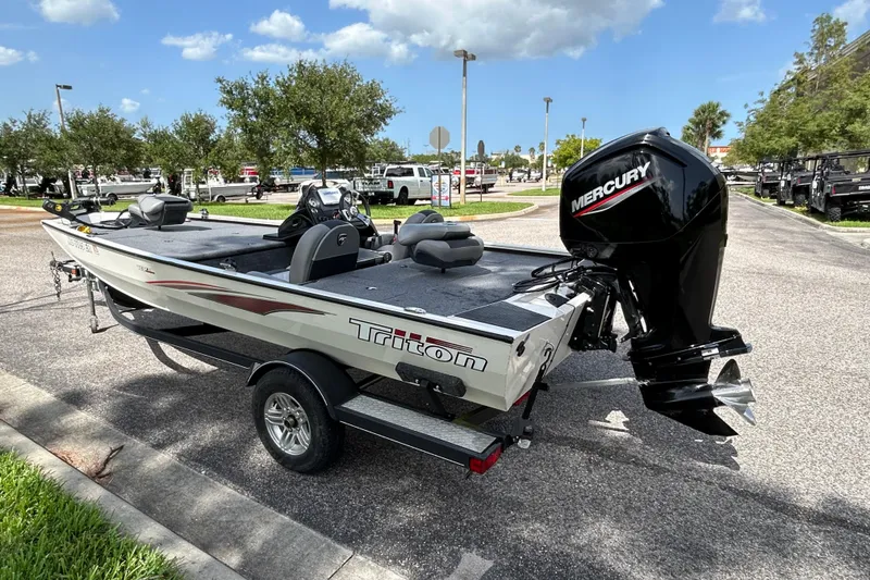 Slide: The Image of 2020 Triton 18 TX boat with Mercury engine on a trailer in a parking lot. - 5