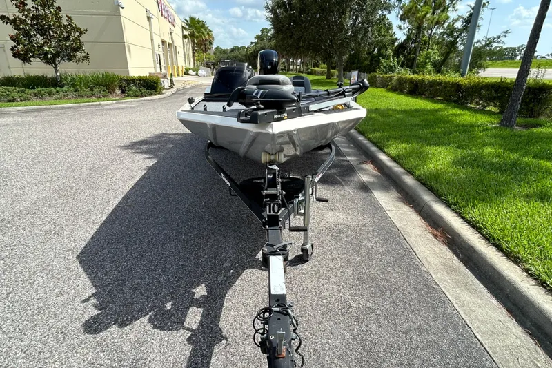 Slide: The Image of 2020 Triton 18 TX boat on trailer, parked on a sunny street. - 2