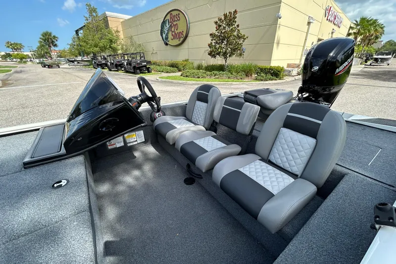Slide: The Image of 2020 Triton 18 TX boat interior with seating, parked near Bass Pro Shops. - 11