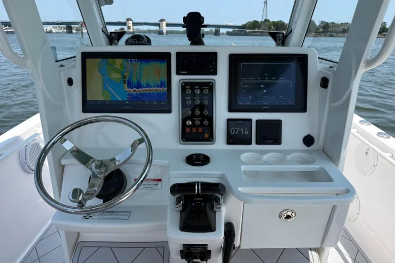 Slide: The Image of Center console of 2015 Everglades 295 boat with navigation screens and steering wheel. - 20