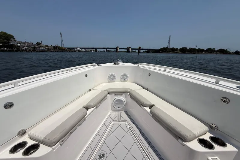 Slide: The Image of 2015 Everglades 295 Center Console boat interior with cushioned seating and cup holders on open water. - 26