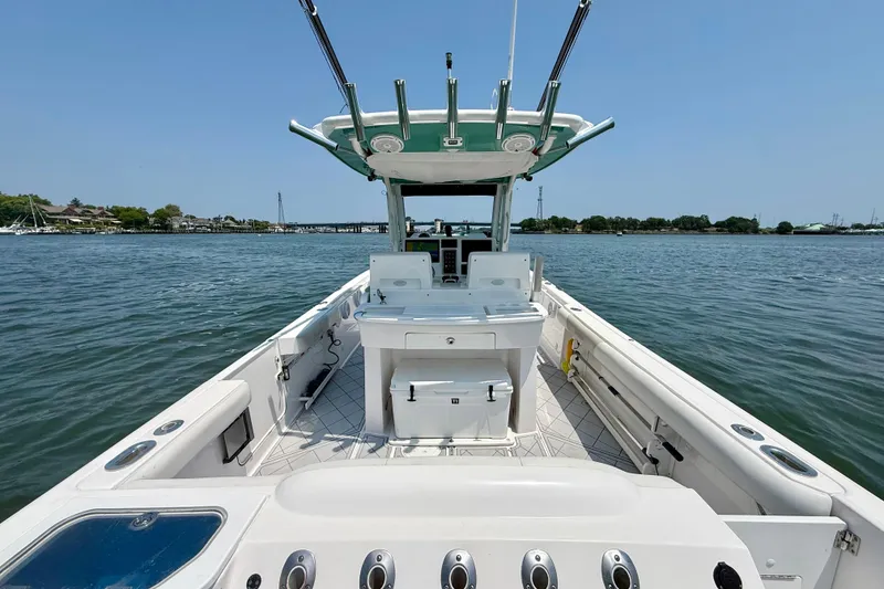 Slide: The Image of 2015 Everglades 295 Center Console boat on calm water, showcasing spacious deck and helm. - 9