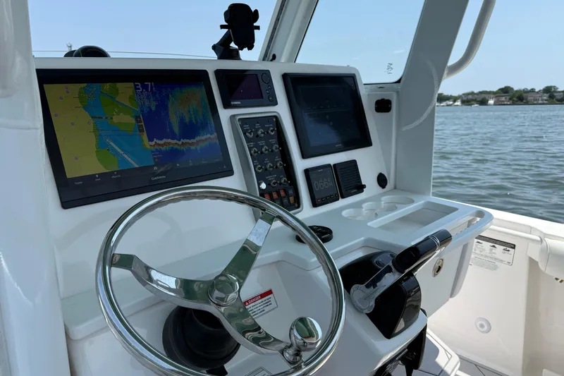 Slide: The Image of Steering console of 2015 Everglades 295 Center Console boat with navigation screens. - 19
