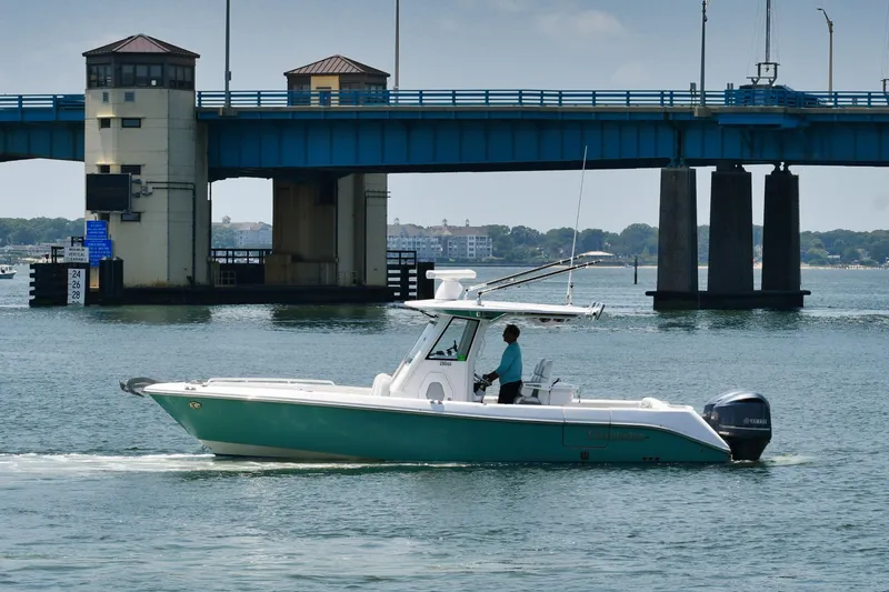 The Image of 2015 Everglades 295 Center Console boat cruising near a blue drawbridge. - 0
