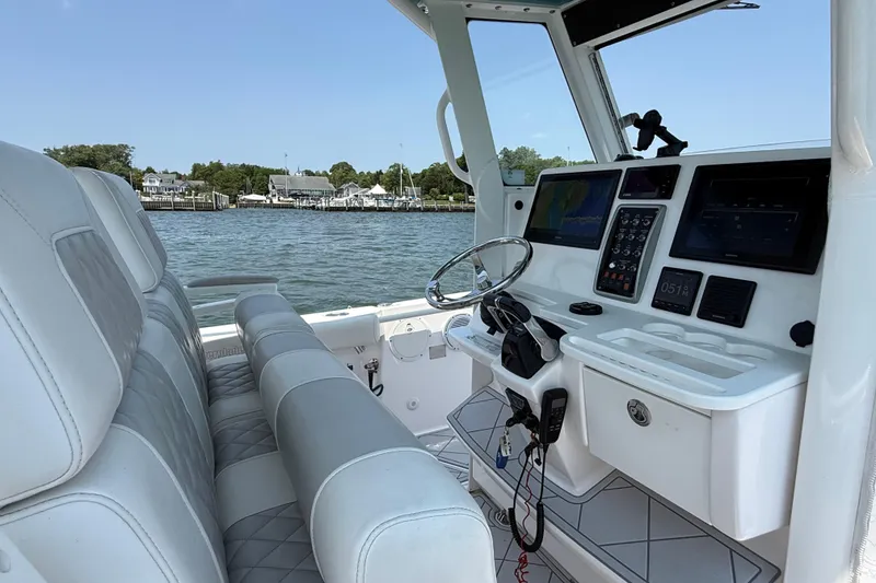 Slide: The Image of 2015 Everglades 295 Center Console boat interior with modern navigation equipment and plush seating. - 17