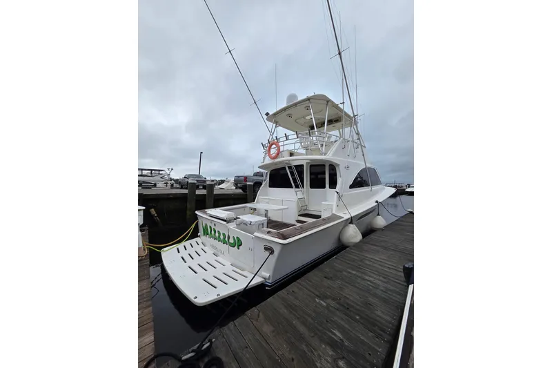 Slide: The Image of 2002 Ocean 56 Super Sport yacht docked at marina under cloudy sky. - 2