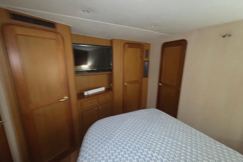 Slide: The Image of Luxurious cabin interior of 2002 Ocean 56 Super Sport yacht with wood paneling and TV. - 22