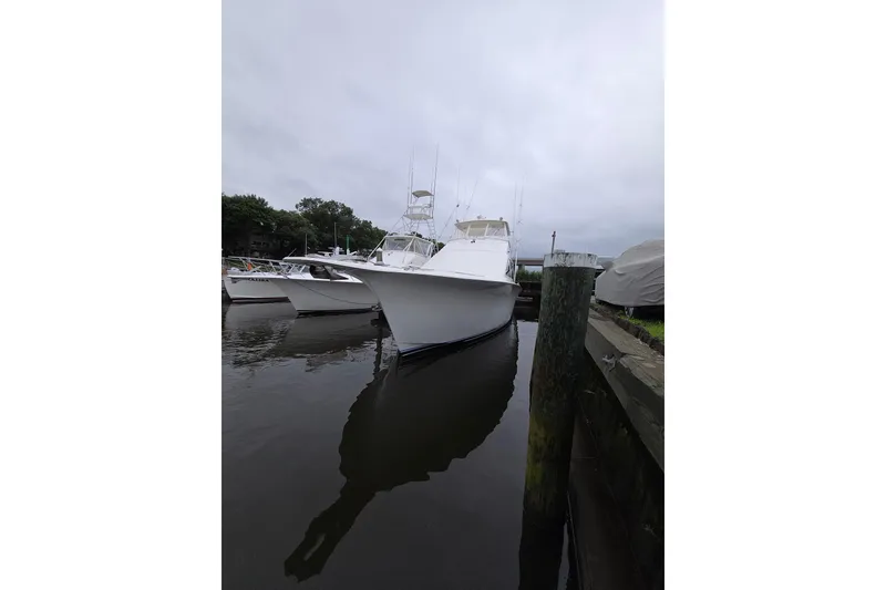 The Image of 2002 Ocean 56 Super Sport yacht docked in a marina, overcast sky. - 0