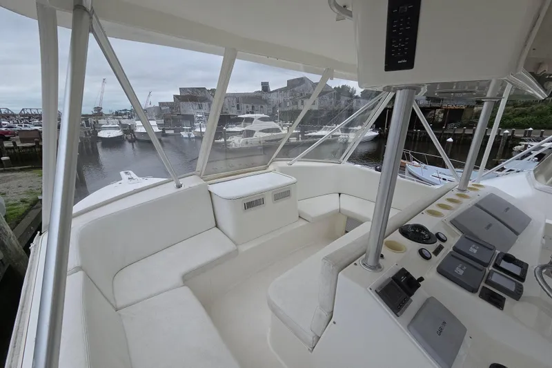 Slide: The Image of 2002 Ocean 56 Super Sport yacht interior with helm and seating area in marina. - 33